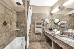 Bathroom with double sinks on granite countertop with bathtub at The Inn at Ohio Northern University in Ada, OH