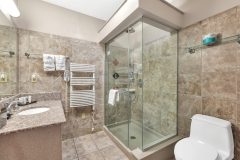 Bathroom with sinks on granite countertop with shower at The Inn at Ohio Northern University in Ada, OH
