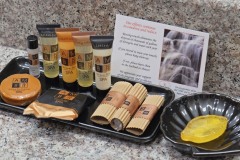 Assortment of spa amenities including lotions and soaps on black tray with card in front on granite table at The Inn at Ohio Northern University in Ada, OH