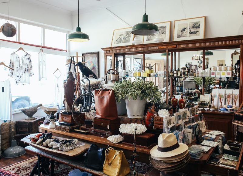 Antique store with various antiques on table near windows displaying vintage clothing and shelves containing soaps and candles near The Inn at Ohio Northern University in Ada, OH