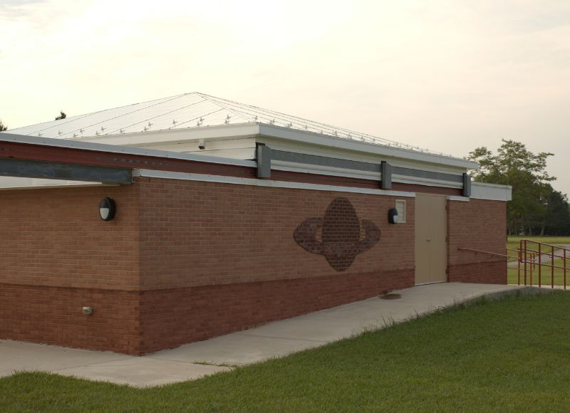 Large brick building with pointed white roof with painting of planet on the outside near stone pathway at The Inn at Ohio Northern University in Ada, OH