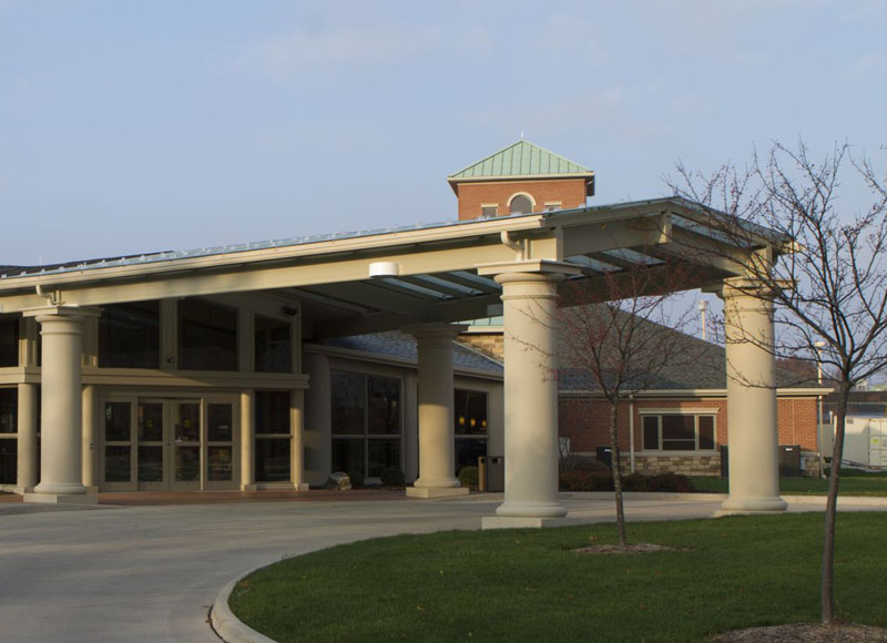 The Inn at Ohio Northern University in Ada, OH entrance overhang near small trees and green lawn near brick building